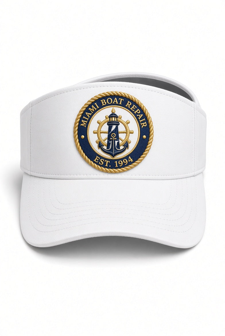 White Miami Boat Repair visor with embroidered navy and gold lighthouse and anchor crest