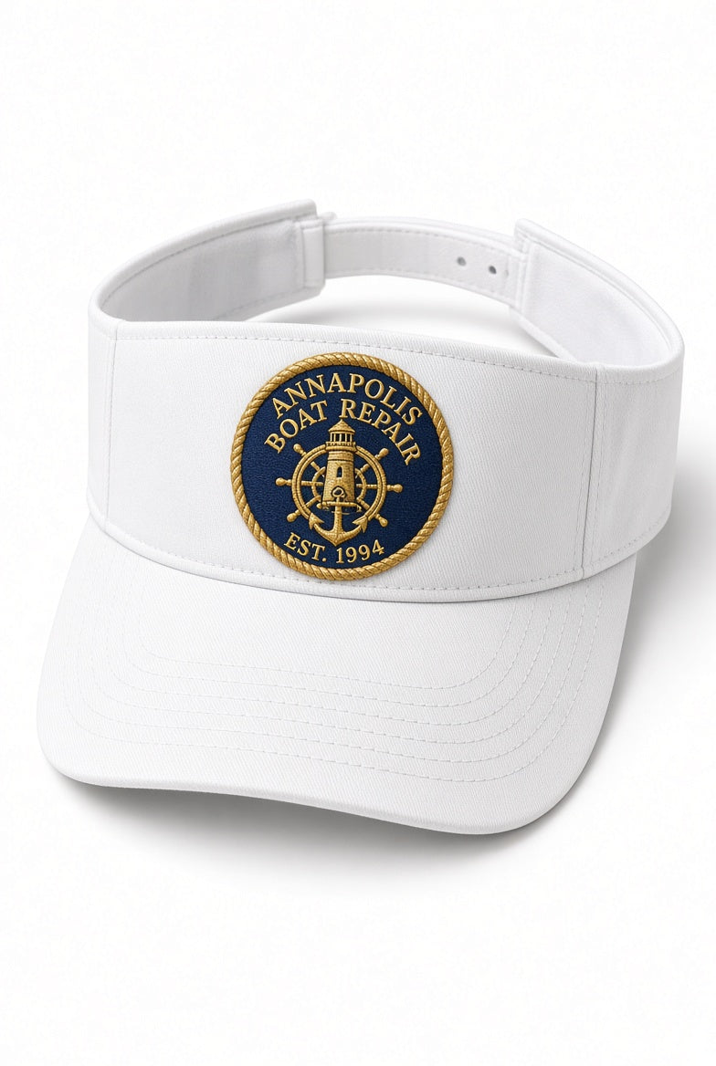 White Annapolis Boat Repair visor with embroidered navy and gold lighthouse crest