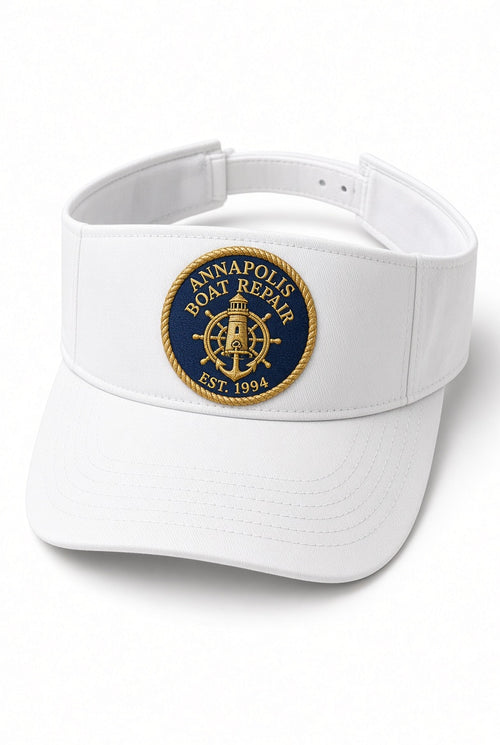White Annapolis Boat Repair visor with embroidered navy and gold lighthouse crest