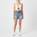 Women wearing white crop top with nautical logo and denim shorts