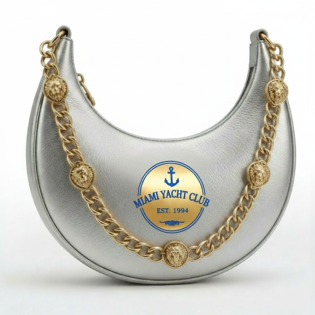 Miami Yacht Club silver metallic crescent hobo bag with navy and gold anchor crest Est. 1994 and gold chain strap with lion head medallion charms